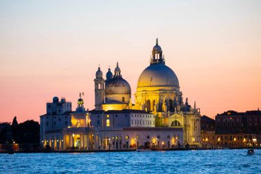 Stunning view of the Venice skyline with the Grand Canal and Basilica Santa Maria Della Salute in the distance during a dramatic sunrise. Picture taken from Ponte Dell Accademia.