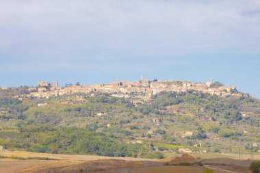 Yazın tipik Toskana manzarası, ekili tarlaları, şarap bahçeleri, selvi ağaçları ve Montepulciano ve Montalcino yakınlarındaki bir tepe ve vadi arazisindeki eski çiftlik binaları, Val d 'Orcia, İtalya