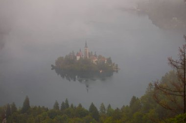 Aerial view of church of Assumption of Maria on the Bled lake. Sunny autumn landscape in Julian Alps, Slovenia, Europe. Beauty of countryside concept background.