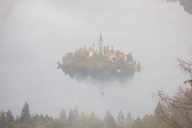 Famous island with old church in the city of Bled. Misty morning with gorgeous lights and colors. Alps mountains in the background. Slovenia, Europe
