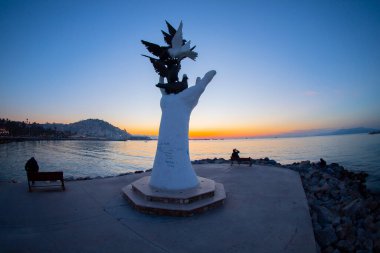 Kusadasi rıhtımında güvercinli barış heykeli..