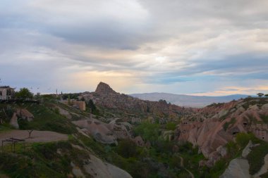 Türkiye 'nin Kapadokya bölgesindeki Uchisar' da bir bahar günü Güvercin Vadisi 'nin yukarısında bir tabela direğinde bir güvercin oturuyor.