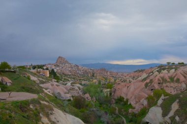  Türkiye 'nin Kapadokya bölgesindeki Uchisar' da bir bahar günü Güvercin Vadisi 'nin yukarısında bir tabela direğinde bir güvercin oturuyor.