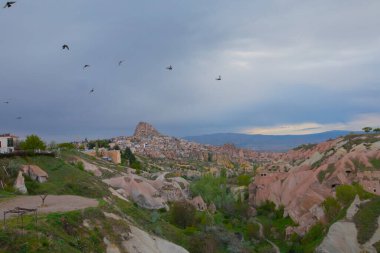  Türkiye 'nin Kapadokya bölgesindeki Uchisar' da bir bahar günü Güvercin Vadisi 'nin yukarısında bir tabela direğinde bir güvercin oturuyor.