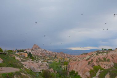  Türkiye 'nin Kapadokya bölgesindeki Uchisar' da bir bahar günü Güvercin Vadisi 'nin yukarısında bir tabela direğinde bir güvercin oturuyor.
