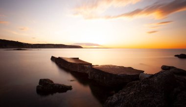 Karaburun lighthouse and wavy harbor photographed using long exposure technique