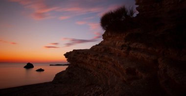 Karaburun lighthouse and wavy harbor photographed using long exposure technique