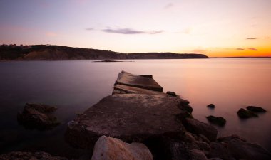 Karaburun lighthouse and wavy harbor photographed using long exposure technique