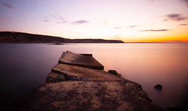 Karaburun lighthouse and wavy harbor photographed using long exposure technique