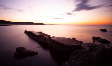 Karaburun lighthouse and wavy harbor photographed using long exposure technique