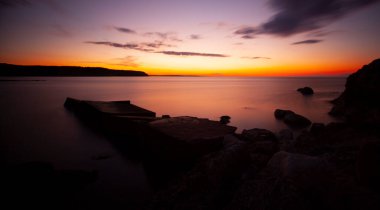 Karaburun lighthouse and wavy harbor photographed using long exposure technique