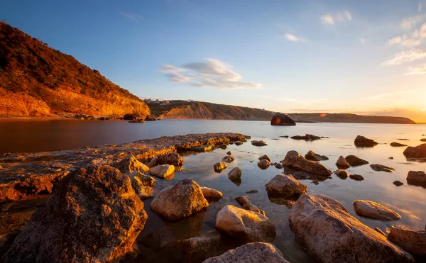 Karaburun lighthouse and wavy harbor photographed using long exposure technique