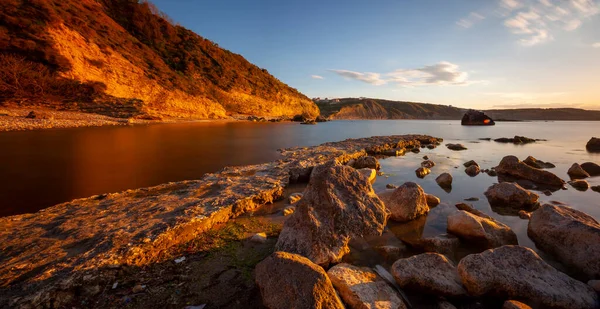 Karaburun lighthouse and wavy harbor photographed using long exposure technique