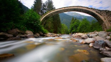 Daytime long exposure with neutral density filter of Firtina Creek and Historical Ottoman Stone Bridge. Kakar Mountains National Park, Rize, Turkey