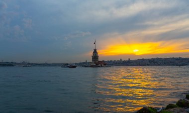İstanbul, Türkiye 'nin sembolü Leander' s Tower olarak da bilinen ünlü Maiden 's Tower (Kiz Kulesi) ile Boğaz' ın üzerinde kızgın bir günbatımı. Duvar kağıdı veya rehber kitap için sahne yolculuğu arkaplanı
