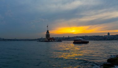 İstanbul, Türkiye 'nin sembolü Leander' s Tower olarak da bilinen ünlü Maiden 's Tower (Kiz Kulesi) ile Boğaz' ın üzerinde kızgın bir günbatımı. Duvar kağıdı veya rehber kitap için sahne yolculuğu arkaplanı