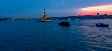 İstanbul, Türkiye 'nin sembolü Leander' s Tower olarak da bilinen ünlü Maiden 's Tower (Kiz Kulesi) ile Boğaz' ın üzerinde kızgın bir günbatımı. Duvar kağıdı veya rehber kitap için sahne yolculuğu arkaplanı