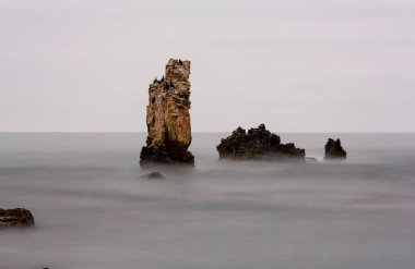 Kayalıklarda dramatik günbatımı manzarası. Renkli deniz görüntüyü şekillendirir. Denizde dev kayalar. Kerpe 'nin kartal kayaları. Kerpe, Kocaeli, Türkiye.