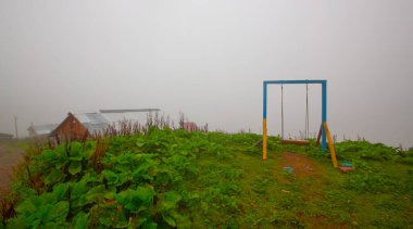 Uçurumun kenarında sallan, insanlar manzaraya karşı sallanıyor.