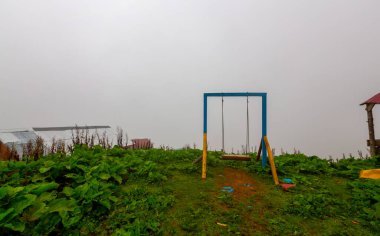 Uçurumun kenarında sallan, insanlar manzaraya karşı sallanıyor.