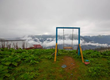 Uçurumun kenarında sallan, insanlar manzaraya karşı sallanıyor.