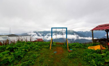 Uçurumun kenarında sallan, insanlar manzaraya karşı sallanıyor.
