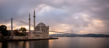 Ortakoy İstanbul manzarası bulutlar Ortakoy Camii ve İstanbul 'daki Boğaz Köprüsü ile güzel bir gün doğumu. İstanbul 'un en iyi turistik beldesi