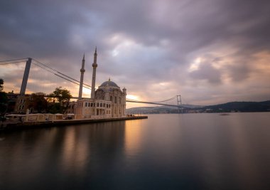 Ortakoy İstanbul manzarası bulutlar Ortakoy Camii ve İstanbul 'daki Boğaz Köprüsü ile güzel bir gün doğumu. İstanbul 'un en iyi turistik beldesi