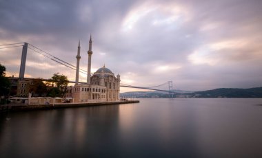 Ortakoy İstanbul manzarası bulutlar Ortakoy Camii ve İstanbul 'daki Boğaz Köprüsü ile güzel bir gün doğumu. İstanbul 'un en iyi turistik beldesi