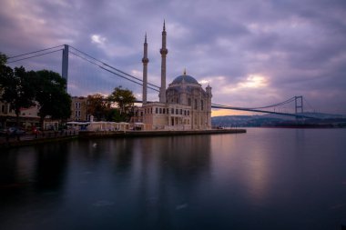 Ortakoy İstanbul manzarası bulutlar Ortakoy Camii ve İstanbul 'daki Boğaz Köprüsü ile güzel bir gün doğumu. İstanbul 'un en iyi turistik beldesi