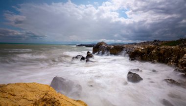 Yüksek deklanşör zamanlarıyla kayalara vuran dalgalar
