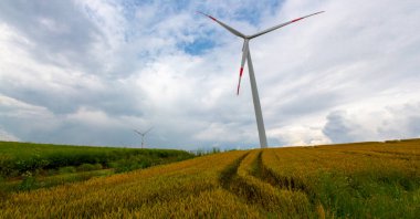 Tarlaların içinde çalışan elektrik yel değirmenleri