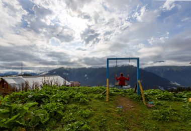 Uçurumun kenarında renkli bir salıncak