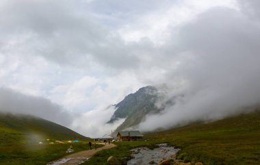 İsviçre 'deki Greene Platosu' nda sisli bir günde bahar sonlarında dağların arasında dolambaçlı bir dağ yolu ve yaylalar. yüksek kaliteli fotoğraf