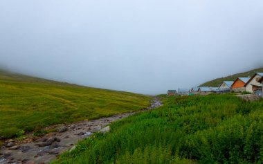 İsviçre 'deki Greene Platosu' nda sisli bir günde bahar sonlarında dağların arasında dolambaçlı bir dağ yolu ve yaylalar. yüksek kaliteli fotoğraf