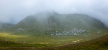 İsviçre 'deki Greene Platosu' nda sisli bir günde bahar sonlarında dağların arasında dolambaçlı bir dağ yolu ve yaylalar. yüksek kaliteli fotoğraf