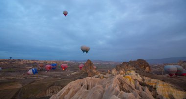 Kapadokya 'da uçan balonlar, gün doğumunda Greme' de. Kapadokya tüm dünyada sıcak hava balonlarıyla uçmak için en iyi yerlerden biri olarak bilinir.. 