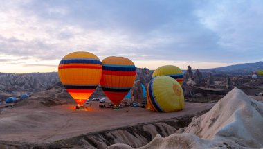 Kapadokya 'da uçan balonlar, gün doğumunda Greme' de. Kapadokya tüm dünyada sıcak hava balonlarıyla uçmak için en iyi yerlerden biri olarak bilinir.. 