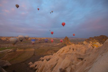 Kapadokya 'da uçan balonlar, gün doğumunda Greme' de. Kapadokya tüm dünyada sıcak hava balonlarıyla uçmak için en iyi yerlerden biri olarak bilinir.. 