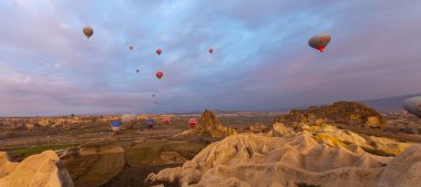 Kapadokya 'da uçan balonlar, gün doğumunda Greme' de. Kapadokya tüm dünyada sıcak hava balonlarıyla uçmak için en iyi yerlerden biri olarak bilinir.. 