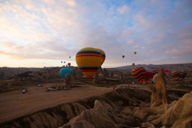 Kapadokya 'da uçan balonlar, gün doğumunda Greme' de. Kapadokya tüm dünyada sıcak hava balonlarıyla uçmak için en iyi yerlerden biri olarak bilinir.. 