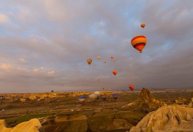 Kapadokya 'da uçan balonlar, gün doğumunda Greme' de. Kapadokya tüm dünyada sıcak hava balonlarıyla uçmak için en iyi yerlerden biri olarak bilinir.. 