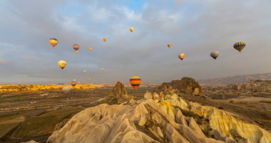 Kapadokya 'da uçan balonlar, gün doğumunda Greme' de. Kapadokya tüm dünyada sıcak hava balonlarıyla uçmak için en iyi yerlerden biri olarak bilinir.. 