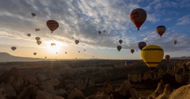 Kapadokya 'da uçan balonlar, gün doğumunda Greme' de. Kapadokya tüm dünyada sıcak hava balonlarıyla uçmak için en iyi yerlerden biri olarak bilinir.. 