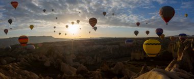 Kapadokya 'da uçan balonlar, gün doğumunda Greme' de. Kapadokya tüm dünyada sıcak hava balonlarıyla uçmak için en iyi yerlerden biri olarak bilinir.. 