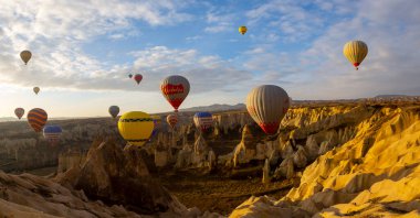 Kapadokya 'da uçan balonlar, gün doğumunda Greme' de. Kapadokya tüm dünyada sıcak hava balonlarıyla uçmak için en iyi yerlerden biri olarak bilinir.. 