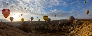 Kapadokya 'da uçan balonlar, gün doğumunda Greme' de. Kapadokya tüm dünyada sıcak hava balonlarıyla uçmak için en iyi yerlerden biri olarak bilinir.. 