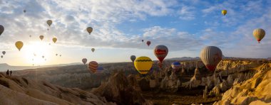 Kapadokya 'da uçan balonlar, gün doğumunda Greme' de. Kapadokya tüm dünyada sıcak hava balonlarıyla uçmak için en iyi yerlerden biri olarak bilinir.. 