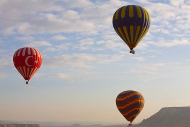 Kapadokya 'da uçan balonlar, gün doğumunda Greme' de. Kapadokya tüm dünyada sıcak hava balonlarıyla uçmak için en iyi yerlerden biri olarak bilinir.. 