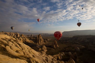 Kapadokya 'da uçan balonlar, gün doğumunda Greme' de. Kapadokya tüm dünyada sıcak hava balonlarıyla uçmak için en iyi yerlerden biri olarak bilinir.. 
